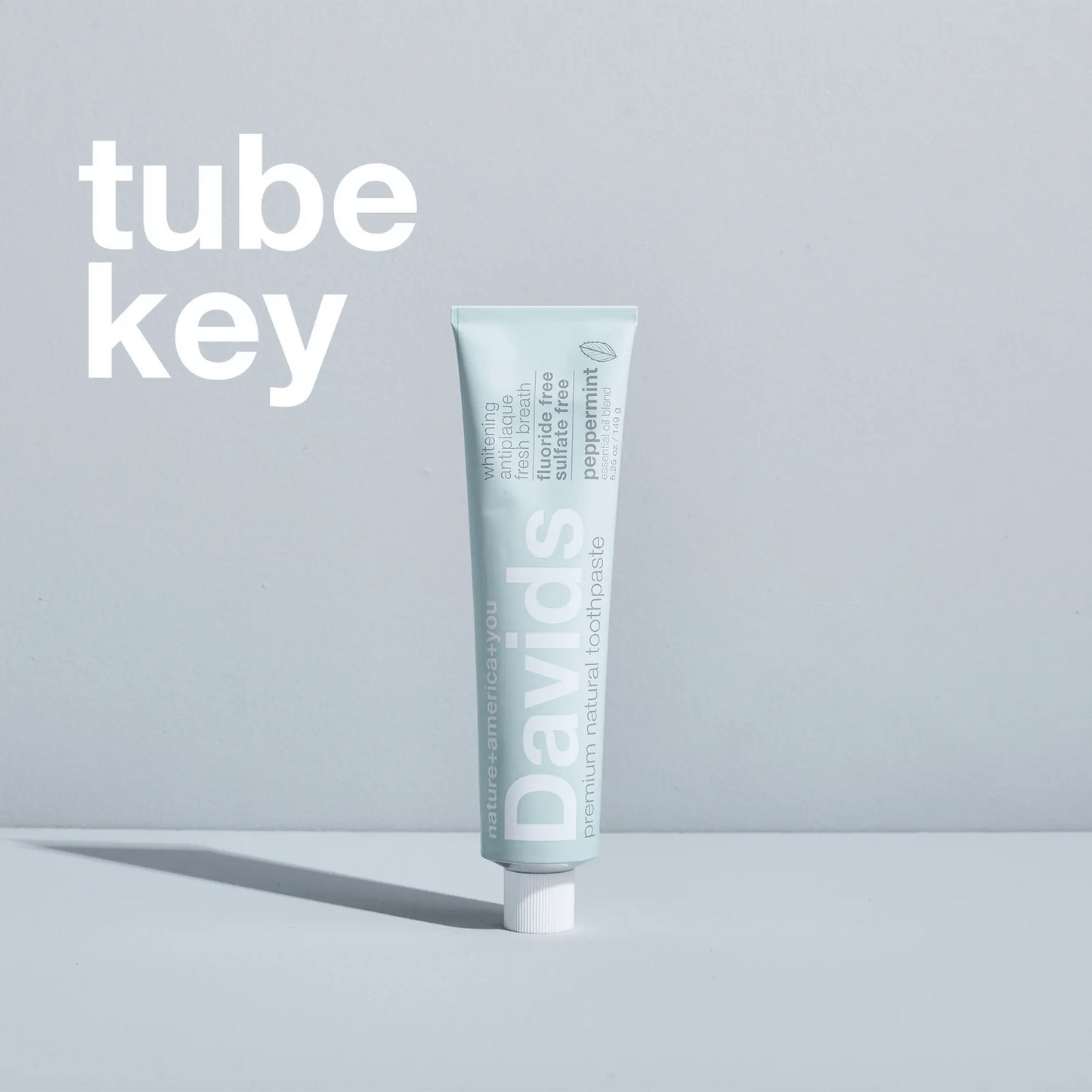 Davids spaustukas metalinėms dantų pastos tūbelėms naudojimo metu, spaudžiant pipirmėtės skonio dantų pastą.