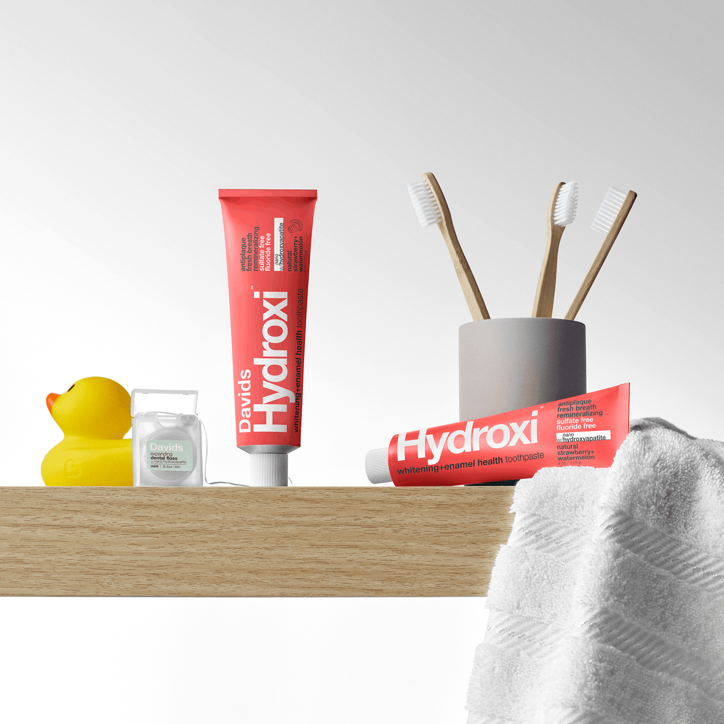 Davids Hydroxi™ balinamoji ir dantų emalį stiprinanti dantų pasta su nano hidroksiapatitu / braškių ir arbūzų skonio, šviesiame fone be pakuotės.