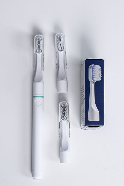 Tromatz Pro bioelektrinis dantų šepetėlis ir Tromatz Pro dantų šepetėlio galvutės (2 vnt.) baltame fone.
