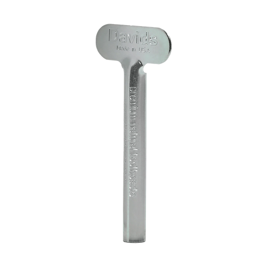 Davids spaustukas metalinėms dantų pastos tūbelėms, be fono.